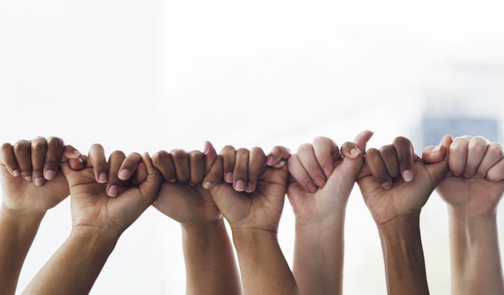 Closeup shot of a group of unrecognisable people linking fingers together