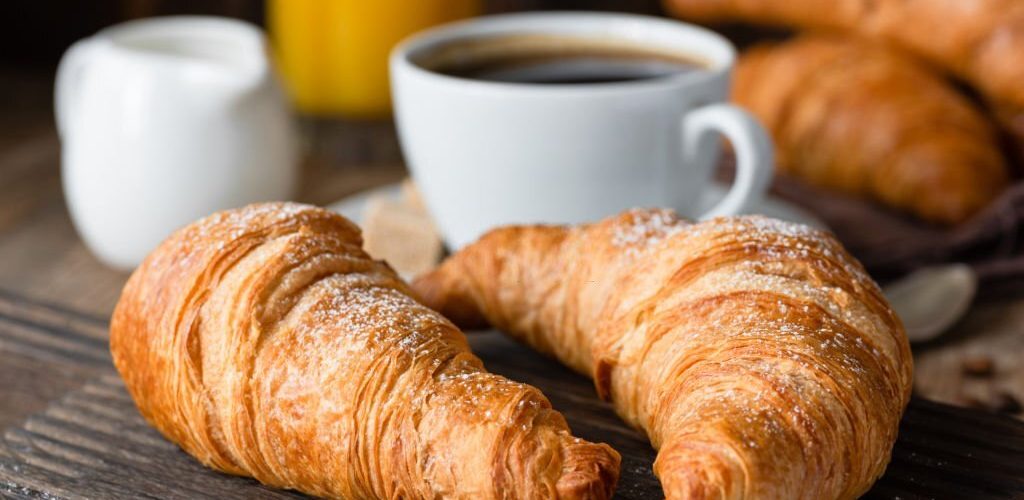Croissants, coffee and orange juice. Continental breakfast. Closeup view