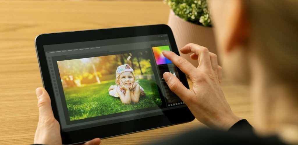 woman photographer using photo editing app on digital tablet