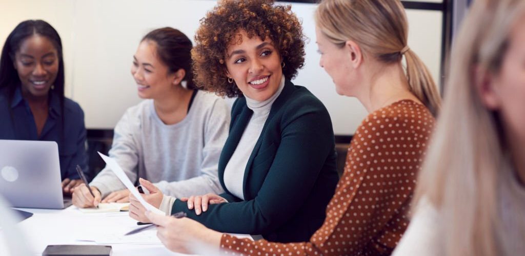Group Of Businesswomen Collaborating In Creative Meeting Around Table In Modern Office