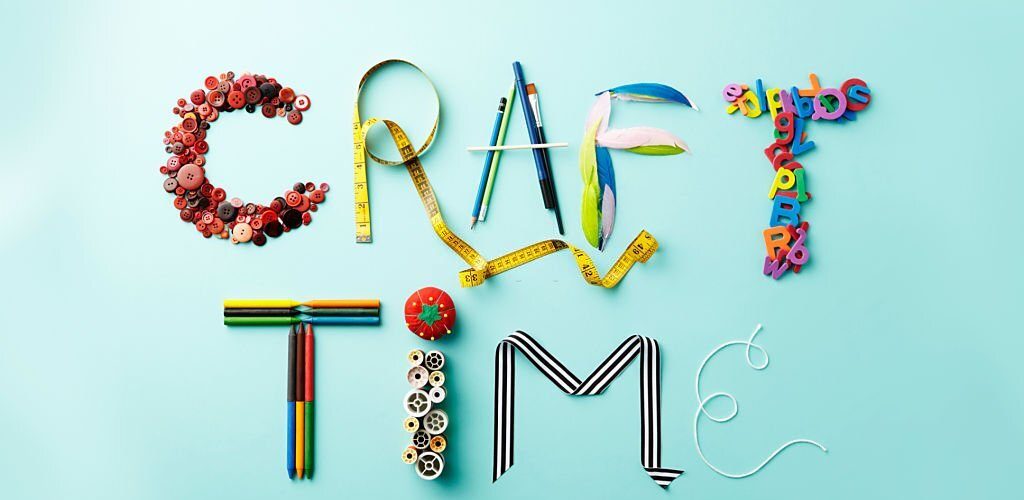Collection of various items used to create arts and crafts photographed in a still life setting from above.