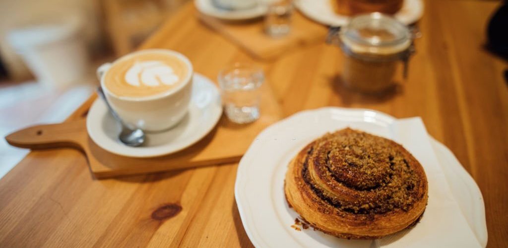 Coffee latte art on wood table with cookie